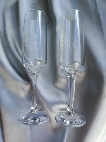 Gri ipek üzerine iki bardak. Gümüş ipek kumaşa çift gözlük takmış. Düğün hediyesi, yıldönümü. Şarap kadehi..