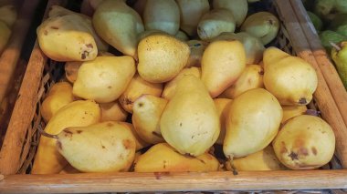Süpermarkette tahta bir kutuda olgunlaşmış sarı armut. Meyve pazarında taze armut satışı. Armut topluyorum..