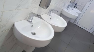 Bir tuvalette dört tane lavabo. Umumi bir tuvalette lavabo. El yıkama. El hijyeni. Arka plan, mesaj için yer. Virüs konseptiyle enfeksiyonun önlenmesi.