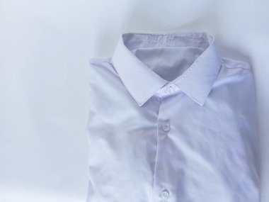 Beyaz arka planda katlanmış beyaz gömlek. Beyaz yakalı. Ütü ve ofis kıyafetlerini yıkamak. Geçmişi. Metin için boşluk.