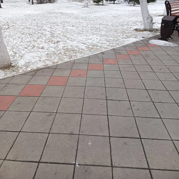 İlk kar yağdı. İnce bir kar tabakası. Yollar, kaldırım taşları kardan temizlendi. Arka plan, mesaj için yer. Soğuk hava, don, sert hava koşulları..