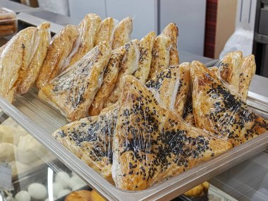 Samsa 'ya siyah susam serpiştirilmiş et yemek odasında sergileniyor, süpermarkette. Hazır hamur işleri. Atıştırmalık Metin için arkaplan, yer.