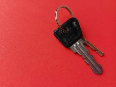 Kırmızı arka planda iki daire anahtarı. Emlakçılık. Bir daire alıyorum. Bir daire, bir ev satışı. Reklam için arka plan, metin için yer. Bir emlakçı. Kiralık konut.
