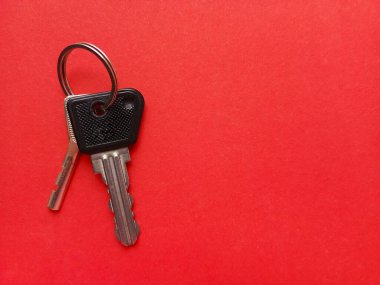 Kırmızı arka planda iki daire anahtarı. Emlakçılık. Bir daire alıyorum. Bir daire, bir ev satışı. Reklam için arka plan, metin için yer. Bir emlakçı. Kiralık konut.