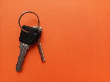Dairenin anahtarları turuncu arka planda. Reklam için arka plan, metin için yer. Emlakçı servisi. Gayrimenkul satışı. İpotek. Bir ev satın almak. 