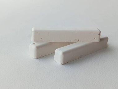 Okulun beyaz tebeşiri beyaz bir masada. Reklam arkaplanı, metin için boşluk.