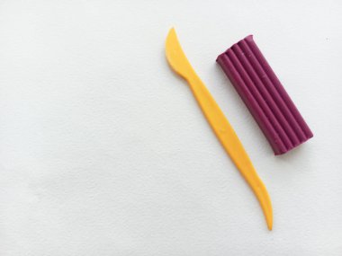 Mor plasticin ve beyaz arka planda plastik deste. Arkaplan, hamur için alan. Çocukların gelişimi için heykel dersi.