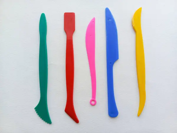 Beyaz arka planda plasticin stokları. Reklam için arka plan, mesaj için alan. Plastikten heykel yapmak için araçlar.