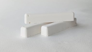 Bir el okul tebeşirini masadan alır. Reklam arkaplanı, metin için boşluk. Yatay video.