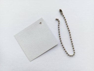 Etiketler için metal bir top zinciri ve masada beyaz bir etiket var. Ürün fiyat etiketleri. Reklam arkaplanı, metin için boşluk.