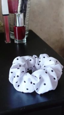 Kadının eli komodindeki uzun saçlar için saten bir kravat alıyor. Saç aksesuarları. Scrunchie yakın plan. Dikey video 9: 16.