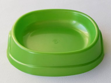 Green plastic bowl for dogs and cats on a white background. Pet products. Feeding pets. Background, space for text. clipart