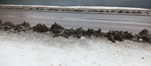 Şehirdeki yol kenarlarında kirli kar var. Araba egzozu havayı ve çevreyi kirletir. Kışın karayolu boyunca kara toz ve is çöker. Kardan yollar temizleniyor..