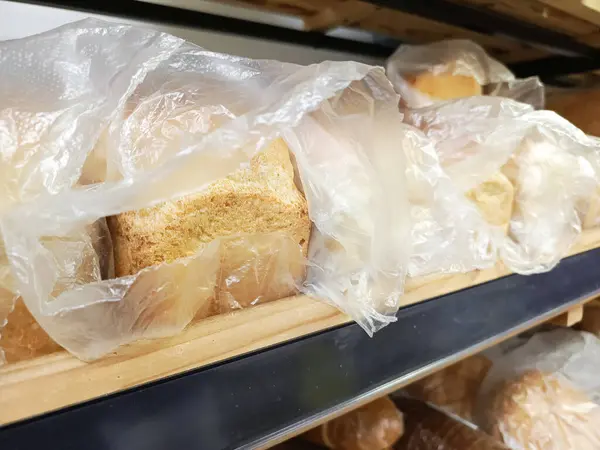 Süpermarket tezgahındaki poşette taze ekmek. Fırın ürünü. Bir üretim fırını. Ekmek, un ve buğday fiyatlarında artış.