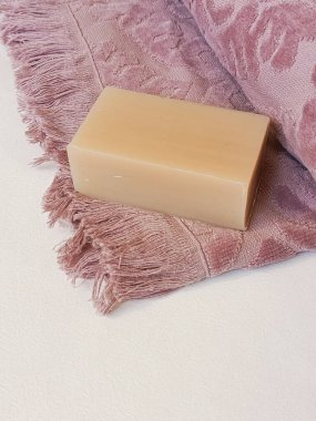 Soap on a pink terry towel close-up on a white background. Personal hygiene products. Shower accessories.  clipart