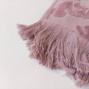 Pembe yumuşak bir havlunun üzerindeki püsküller. Fırfırlı banyo havlusu..