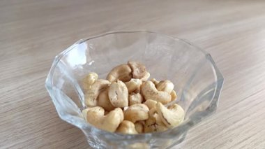 Kaju fıstıkları masanın üzerindeki bir fincana dökülüyor. Yüksek protein içerikli fındık. Taze kabuklu kaju..
