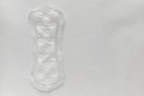 Beyaz arka planda hijyenik ped. Yeniden kullanılabilir günlük ped. Bir kadında adet döngüsü.