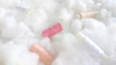 Pembe, bej ve beyaz iplikli bobinler havadar yumuşak bulutlar, sintepon, pamuk. Dikiş dikme, atölye.
