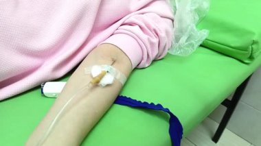 Serum takılı bir kadın eli. Bir kadının kolunda serum sondası. Bir infüzyon sistemi kullanarak damardan ilaç veriliyor.. 