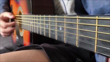 Genç bir çocuk kanepede oturuyor ve gitar çalıyor. Gitar telleri. Gitar çalıyorum. Müzik dersi.. 
