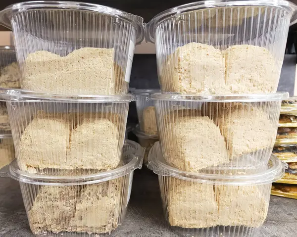 Süpermarket vitrininde plastik kaplarda fıstık halkası. Fındıktan yapılmış doğu tatlıları. Halva 'nın faydaları.
