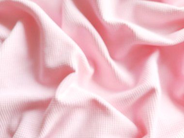 Pembe kumaşın katları çözülmüş. Hassas pembe kumaş arka plan. Kadın kıyafetleri, kozmetik ürünleri, çocuk kıyafetleri reklamları için arka plan.