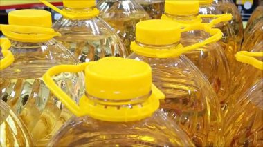 Süpermarkette bir sürü plastik ayçiçeği yağı şişesi var. Temel ihtiyaçlar. Toptan alım satım. Rafine edilmiş ve rafine edilmemiş şişe yağı..