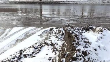 Asfalt yol boyunca kirli kar. Karda siyah is var. Otobanda su birikintileri. Çevre kirliliğinden kaynaklanan çevresel kirlilik emisyonlarla. 