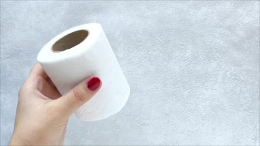 Bir kadının elinde bir rulo beyaz kağıt havlu. Kolunda tuvalet kağıdı var. Tek kullanımlık kağıt peçeteler. Hijyen. 