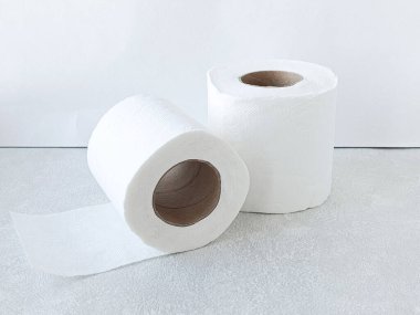 Masanın üzerinde iki rulo beyaz tuvalet kağıdı var. Kağıt havlu ruloları, masanın üstünde peçeteler. Birincil ve ikincil selüloz. 
