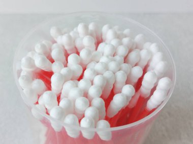 Plastik bir kapta tek kullanımlık pamuklu çubuklar. Pamuklu çubukların promosyon fotoğrafı. Kulak temizliği..