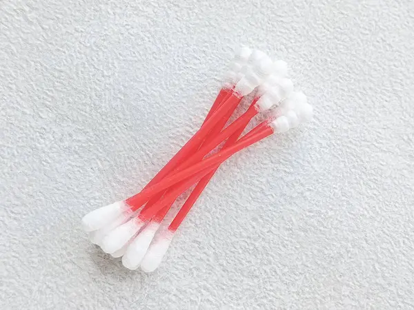 Gri bir masanın üzerinde bir yığın pamuk bezi duruyor. Kenarında yazı için bir yer var, üst görünüm. Kulaklar için hijyenik pamuk örnekleri. 