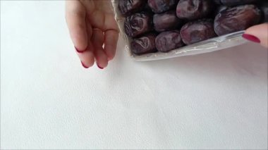 Tarihler karton bir kutudan beyaz bir masaya dökülür. Dükkanlara teslim edilmeden önce toplanma tarihleri. Doğal oryantal kurutulmuş meyve.. 
