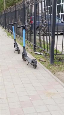 Elektrikli scooterlar şehrin asfalt yolunda duruyor. Elektrikli taşıma ile seyahat edin. Şehirde elektrikli scooter kiralama. 