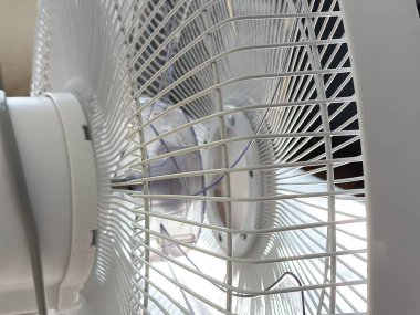 Oturma odasındaki ahşap masada modern elektrikli vantilatör. Metin için boşluk