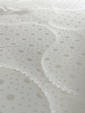 Beyaz yorganlı su geçirmez yatak. Ortopedik yatak, doku