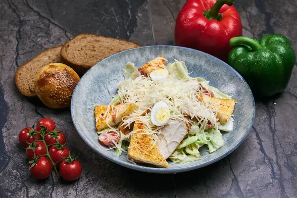 Peynirli tavuk göğsü ve koyu arkaplanda taze domates salatası. Üst görünüm, boşluk kopyala