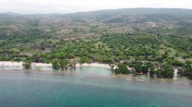 Dağlara yakın küçük dalgalarla tropikal sahil ve deniz suyunun havadan görünüşü. Seyahat konsepti.