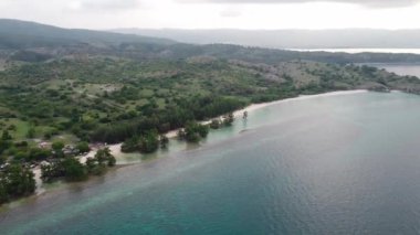 Dağlara yakın küçük dalgalarla tropikal sahil ve deniz suyunun havadan görünüşü. Seyahat konsepti.
