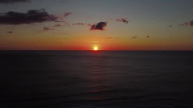 Deniz üzerinde günbatımı ufkunun havadan görünüşü. Sinema robotu hava görüntüsü güzel bir akşam güneşi denizin üstünde. Güneş yolu deniz yüzeyine yansır..