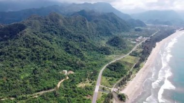 Yeşil dağlara yakın küçük dalgalarla tropikal plaj ve turkuaz deniz sularının havadan görüntüsü. Seyahat konsepti.