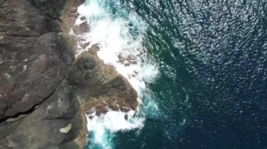 Deniz mavisi drone 'un havadan görüntüsü kayalık bir dağın yüksek uçurumunda kırılıyor..