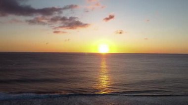 Deniz üzerinde günbatımı ufkunun havadan görünüşü. Sinema robotu hava görüntüsü güzel bir akşam güneşi denizin üstünde. Güneş yolu deniz yüzeyine yansır..