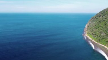 Dağlara yakın küçük dalgalarla tropikal sahil ve deniz suyunun havadan görünüşü. Seyahat konsepti.