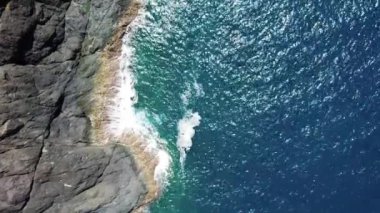 Deniz mavisi drone 'un havadan görüntüsü kayalık bir dağın yüksek uçurumunda kırılıyor..