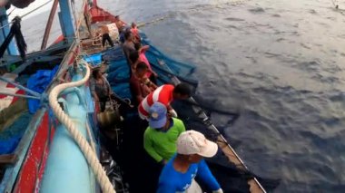 Aceh, Endonezya - 1 Haziran 2024: Balıkçı okyanustan ağlar içinde balık yakaladı. Endüstri, ağa takılmış balık avlayarak gelişiyor. 4K.