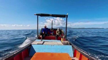 Aceh, Endonezya - 24 Temmuz 2024: Balıkçılar geleneksel tekneyle balığa gider. Hareket halindeki tekneden deniz pelerini. Balık ve balıkçılık kavramı.