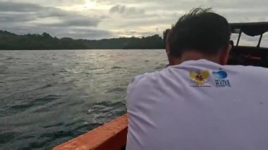 Aceh, Endonezya - 24 Temmuz 2024: Balıkçılar kötü hava şartları nedeniyle balıkçılığı iptal ettiler. Hareket halindeki tekneden deniz pelerini. Balık ve balıkçılık kavramı.