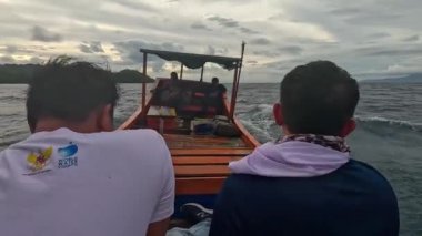 Aceh, Endonezya - 24 Temmuz 2024: Balıkçılar kötü hava şartları nedeniyle balıkçılığı iptal ettiler. Fırtına ve büyük dalgalar sırasında hareket eden tekneden deniz pelerini. Balık ve balıkçılık kavramı.